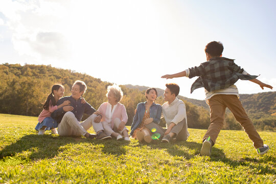 Happy Chinese family playing on meadow