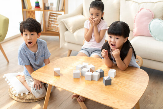 Cute Chinese children watching TV in living room