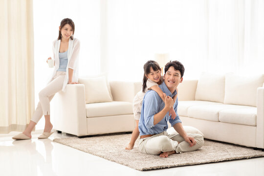 Happy Young Family Relaxing In Living Room