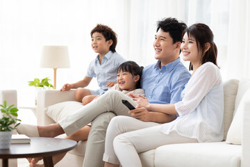 Happy young family watching TV at home