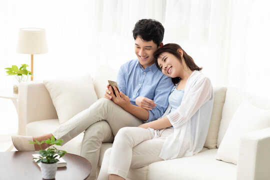 Cheerful young couple using smart phone