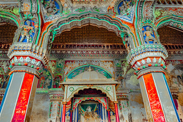 Obraz premium Thanjavur, Tamil Nadu, India - The high arches artworks and colorfully painted wall murals and ceilings of the ancient 17th-century durbar hall Maratha Palace in the town of Thanjavur