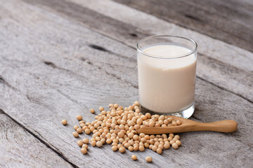 Soybean and glass of soy milk isolated on wooden table background.