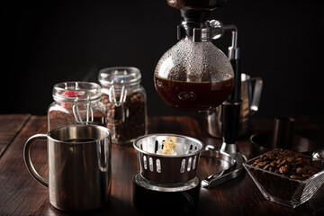 Vacuum coffee maker also known as vac pot, siphon or syphon coffee maker. Metallic cup and toasted...