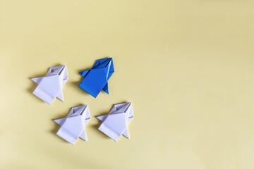 The concept of struggle and competition. A blue paper car competes with white cars on a yellow background
