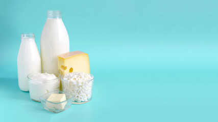 Fototapeta na wymiar The concept of consumption of milk products. Milk, kefir, sour cream, cheese, butter and cottage cheese in a glass container on a light background of kopi space