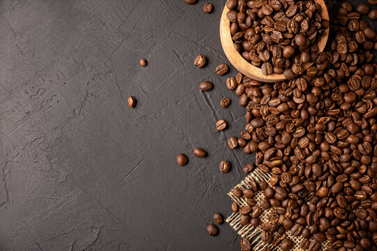 Organic toasted coffee beans on rustic black stone table with copy space for your text. top view image