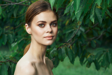 Fototapeta premium beautiful woman attractive look bare shoulders green leaves cropped view