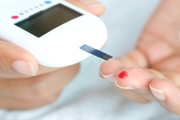 hand of people check diabetes and high blood glucose monitor with digital pressure gauge. Healthcare and Medical concept