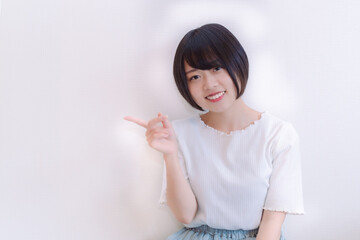 右手で指差し案内する女性