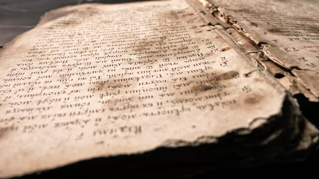 Background of book with ancient writings, mystical secrets of past, mysteries of history. Slider shot macro view of religious literature, archival manuscripts