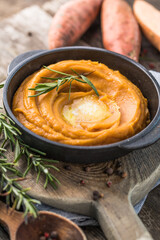 Spicy mashed sweet potato or sweet potato puree with rosemary in a saucepan on a table.  top view from above.