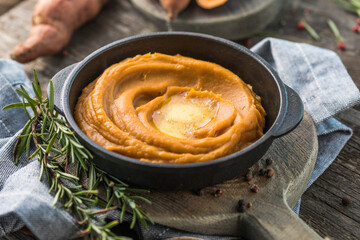 Spicy mashed sweet potato or sweet potato puree with rosemary in a saucepan on a table.  top view from above.