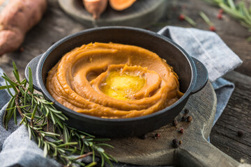 Spicy mashed sweet potato or sweet potato puree with rosemary in a saucepan on a table.  top view from above.