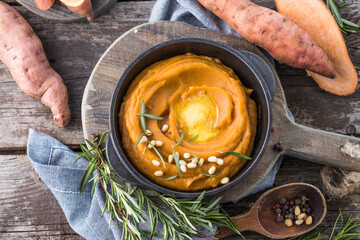 Spicy mashed sweet potato or sweet potato puree with rosemary in a saucepan on a table.  top view...