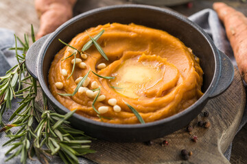 Spicy mashed sweet potato or sweet potato puree with rosemary in a saucepan on a table.  top view from above.