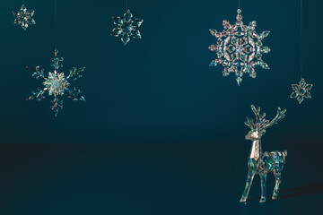  Winter scene with Christmas decorations made of crystal glass. Xmas deer and snowflakes on dark...