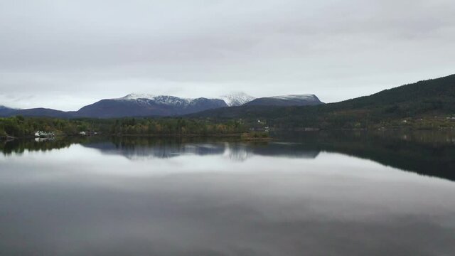Aerial View Of Calm Lake With Mountains View On a Misty Day, Norway. - drone shot, pull in