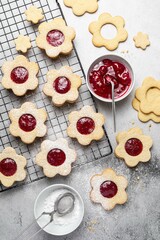 Linzer Christmas or New Year cookies filled with jam and dusted with sugar on grey background. Traditional Austrian Christmas cookies. Shortbread cookies. Homemade sweet present.