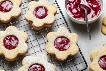 Linzer Christmas or New Year cookies filled with jam and dusted with sugar on grey background....