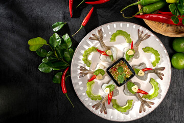 Raw Shrimp in fish sauce and many herbs. A delicious recipe from Asia and spices ingredients for cooking on dark black wooden table background, Thai food, Asian foods, Thailand restaurant menu