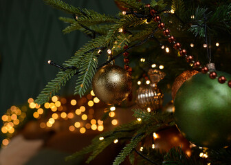 Christmas tree with gold, green balls, beads, garlands on a gold bokeh. Christmas mood . Happy New Year and Merry Christmas