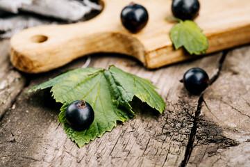Fresh black currant. A handful of berries on a wooden table