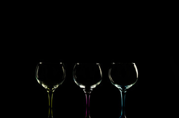 Sharp of three gin glass cups with color against black background