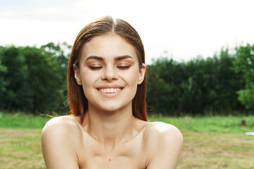 portrait of a woman in a field outdoors bare shoulders clear skin close-up