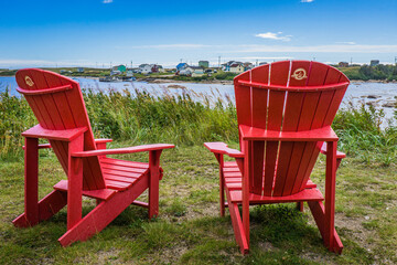 Fototapeta premium Canada Parks red adirondack chairs in Aguanish, a small town located in Cote Nord region of Quebec (Canada)