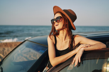 Obraz na płótnie Canvas woman on the beach is with a car wearing sunglasses travel