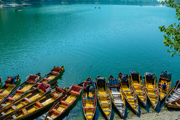 Colorful boats on the blue waters of Naini Lake in Nainitaal, Uttrakhand, India.