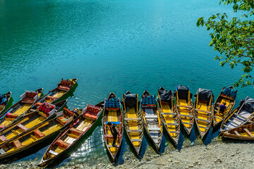 Colorful boats on the blue waters of Naini Lake in Nainitaal, Uttrakhand, India.