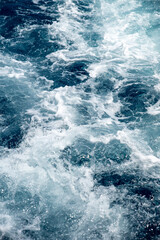 Fototapeta na wymiar Rough deep turquoise and blue sea with white foam texture background