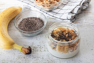 A healthy and healthy breakfast of homemade yoghurt with banana, granola and chia seeds.