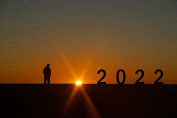 Silhouette of 2022 year letters on the rooftop with sunset light, Concept new success , target - New year travel and business goal 