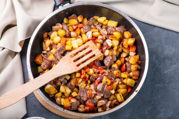 Roast with potatoes, mushrooms and meat, top view.