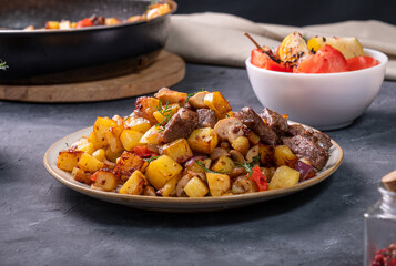 Appetizing potatoes fried until golden brown with mushrooms and beef. homemade food