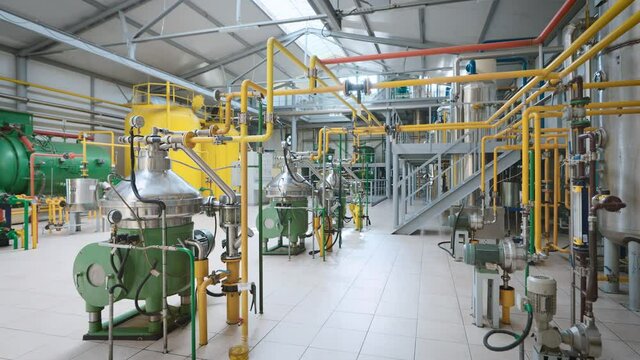 Large light workshop with metal containers and a complex piping system.