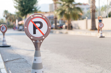 cone warning about a parking ban of automobile and cars. traffic safety sign on city street road....