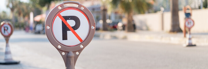 cone warning about a parking ban of automobile and cars. traffic safety sign on city street road....