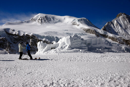 sculpture in snow on Mittelallalin created for 30 anniversary of Metro Alpin, in background left - Alphubel 4206 m and on right Taschhorn 4490 m and Dom 4545 m, Saas-Fee, Wallis, Valais, Switzerland