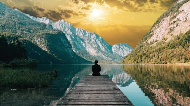 Silhouette, man, person sitting in front of lake, mountains, beautiful nature in park, cinemagraph sunset sky replacement effect, solitude, relaxing.