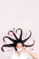 A beautiful young woman lies with long hair, the tools for lamination and care of eyebrows and...