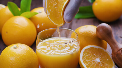 Yellow orange fruits and fresh orange juice. Squeezing out the fresh orange.