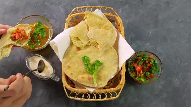 Homemade corn flatbread female hand cilantro greens tomato salsa. Handmade mexican tortillas vegetable salad Traditional Indian Punjabi Makki ki roti bread plate 4K Wheat flour dough authentic cuisine