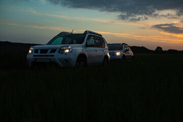 Fototapeta na wymiar two suv cars on sunset. road trip concept