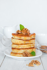 Pancakes with nuts and honey on a white background.