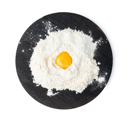 Raw egg yolk in pile of flour on white background