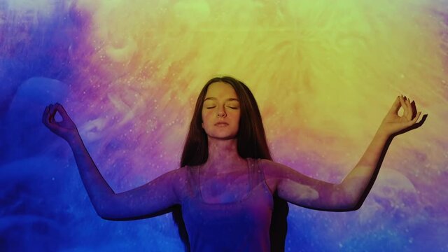 Spiritual enlightenment. Yoga meditation. Mindfulness relaxation. Esoteric healing. Peaceful inspired girl in nirvana zen in glowing yellow purple blue chakra mist cloud heaven light.